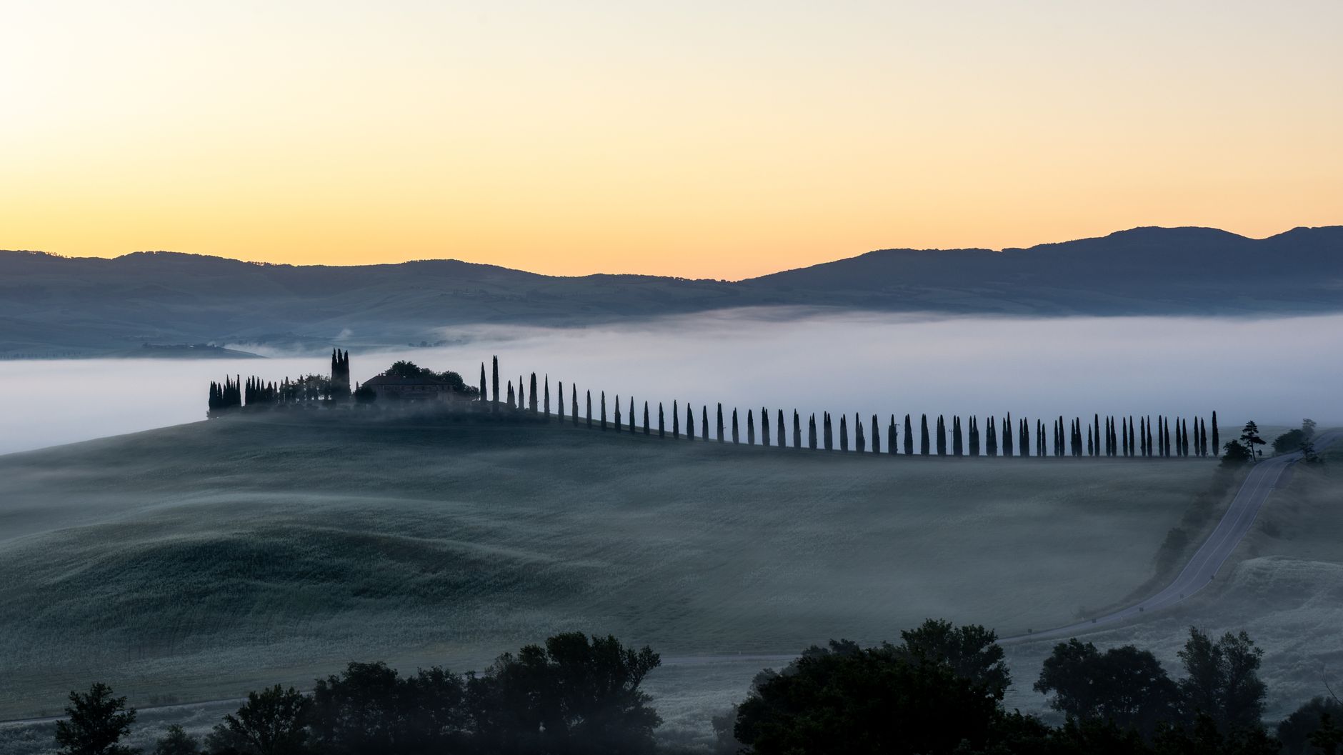 Tuscan stone farmhouse among rolling hills